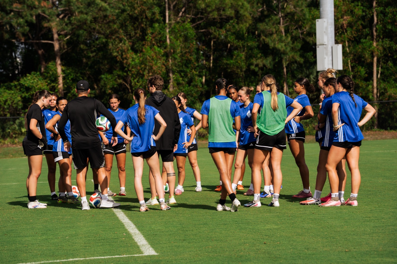 Players gathered with a coach on the field