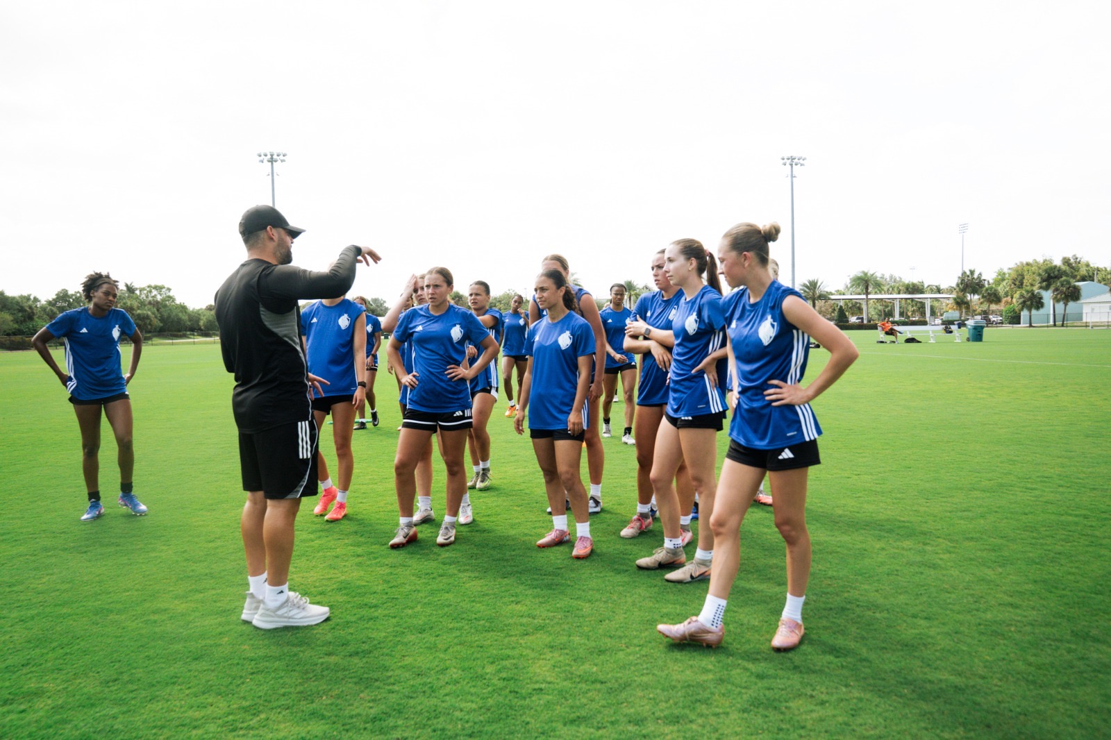 Coach speaking to players on the field