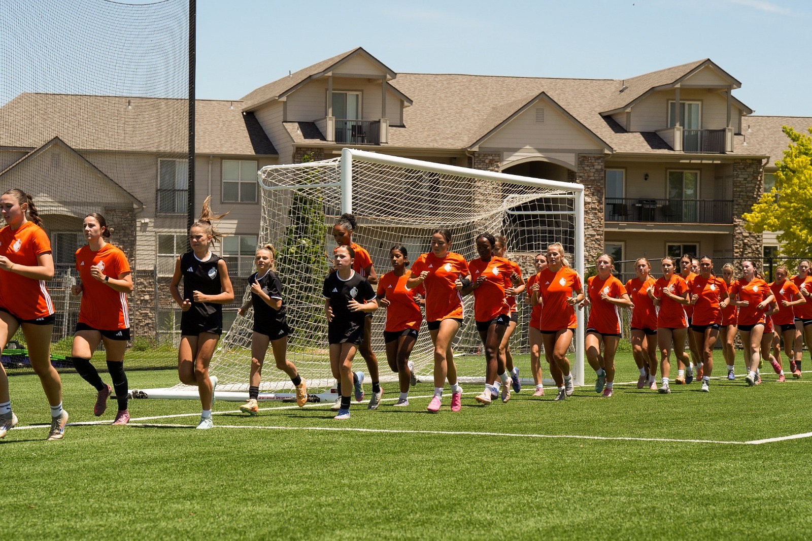 Soccer players running in front of a goal
