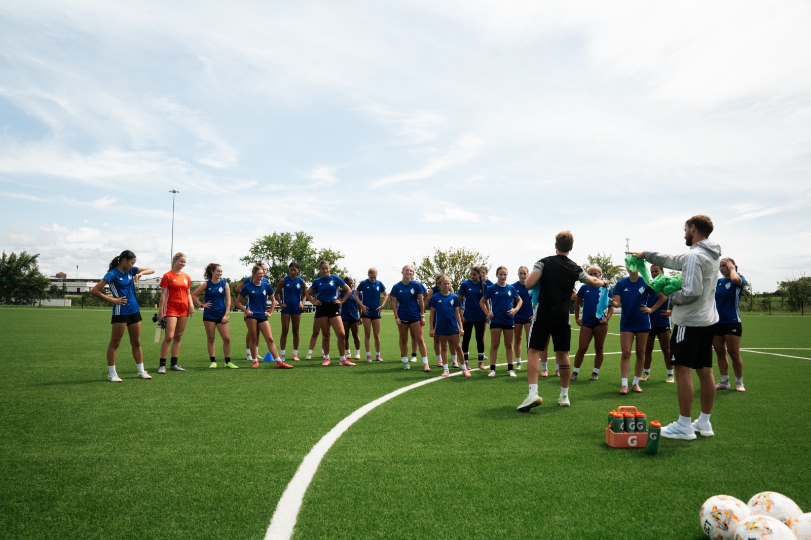 Soccer players and coaches gathered on a training field